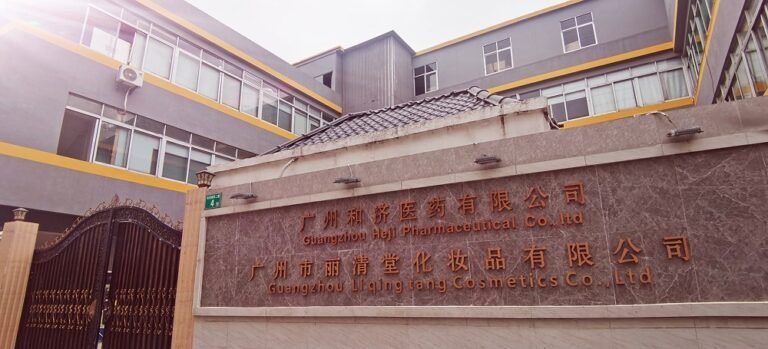 Exterior view of the Evona Cosmetics factory showing the building complex, front gate, and company signage on the entrance wall.