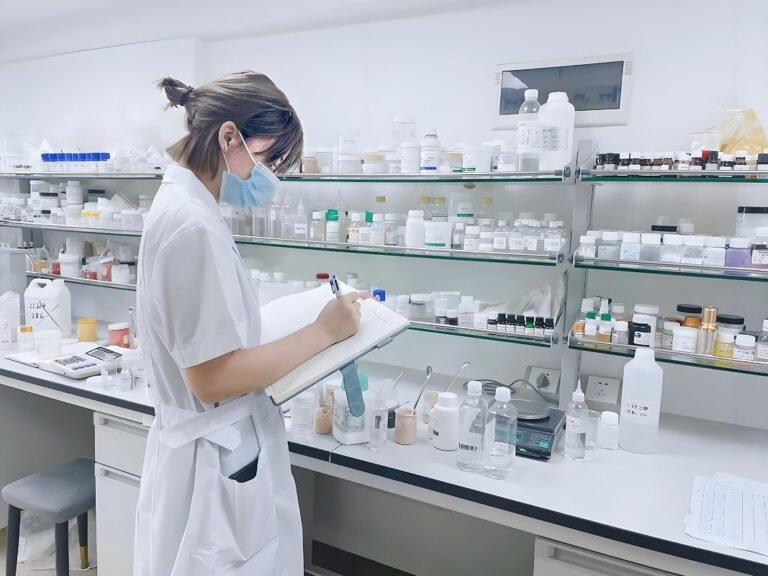 Lab technician recording cosmetic formulation data in a laboratory.