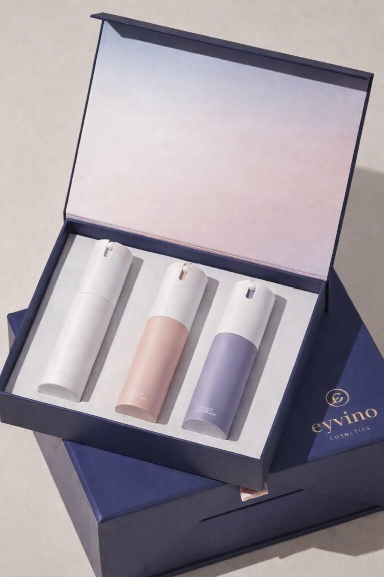 Three cosmetic bottles in a branded gift box with a hinged lid.