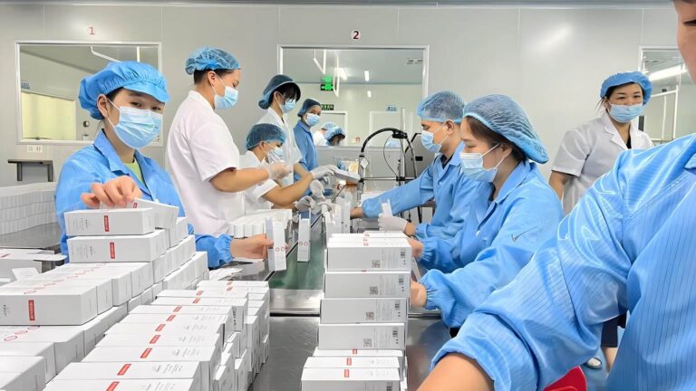 Workers packing cosmetics in cleanroom